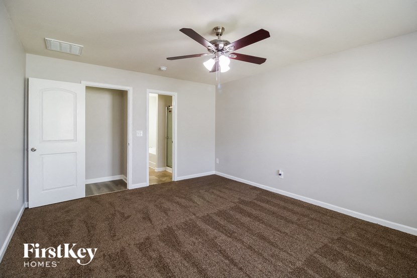 an empty living room with a ceiling fan