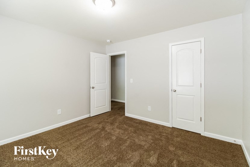 a bedroom with a carpeted floor and two white doors