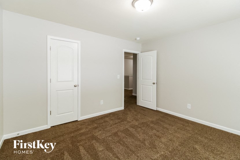a bedroom with two doors and a carpeted floor