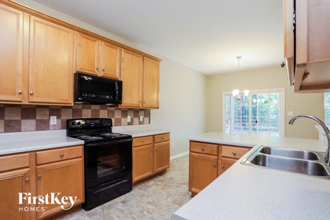 A kitchen with wooden cabinets and a black stove top oven.