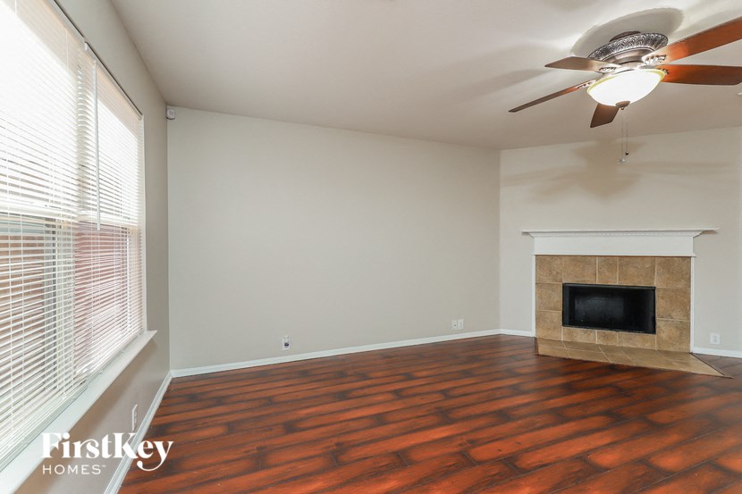 a living room with a fireplace and a ceiling fan