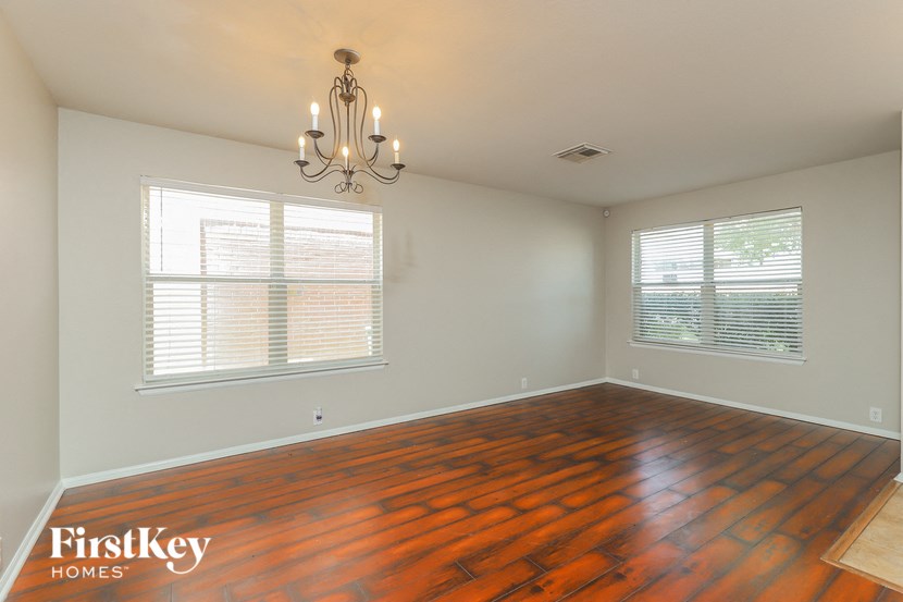 the living room of a home with wood floors and a chandelier
