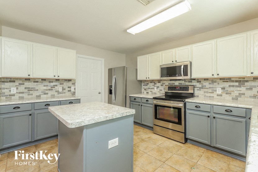 a kitchen with stainless steel appliances and blue cabinets