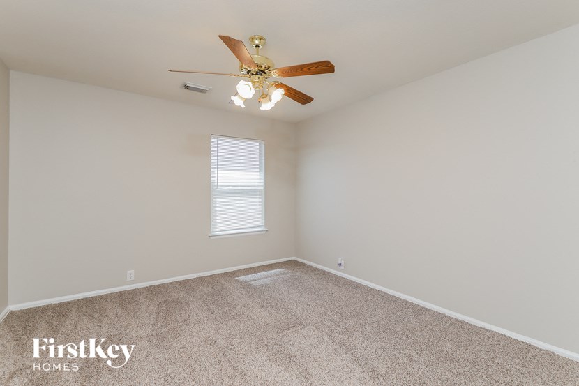 a bedroom with carpet and a ceiling fan