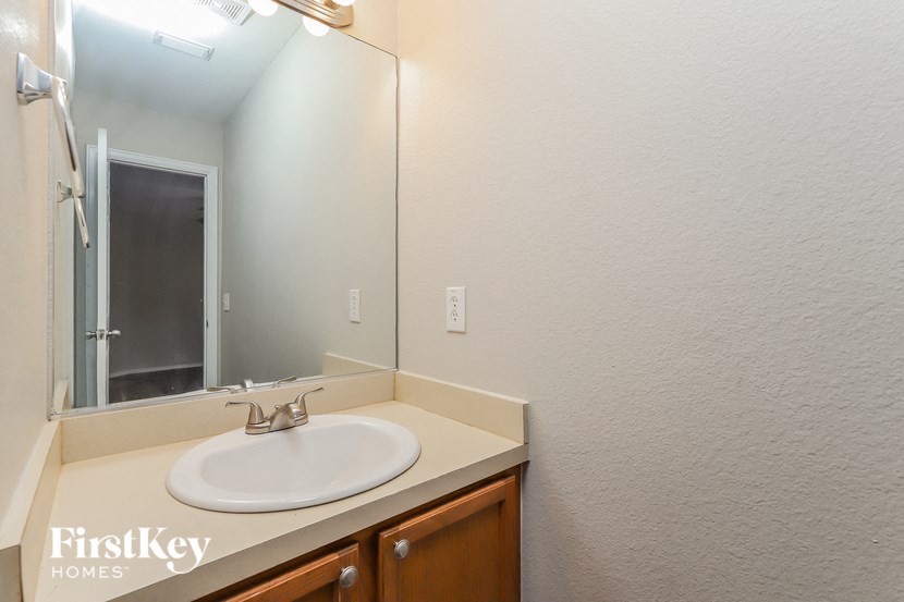 the bathroom has a large mirror and a sink