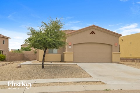 a house with a driveway and a tree in front of it
