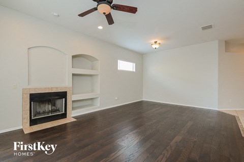 a living room with a fireplace and a ceiling fan