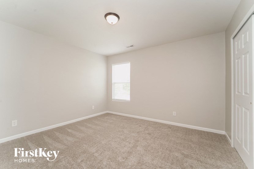a spacious living room with carpet and a window