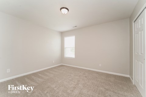a spacious living room with carpet and a window