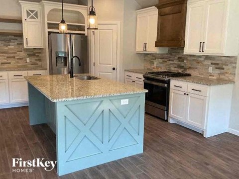 A kitchen with a blue island in the middle.