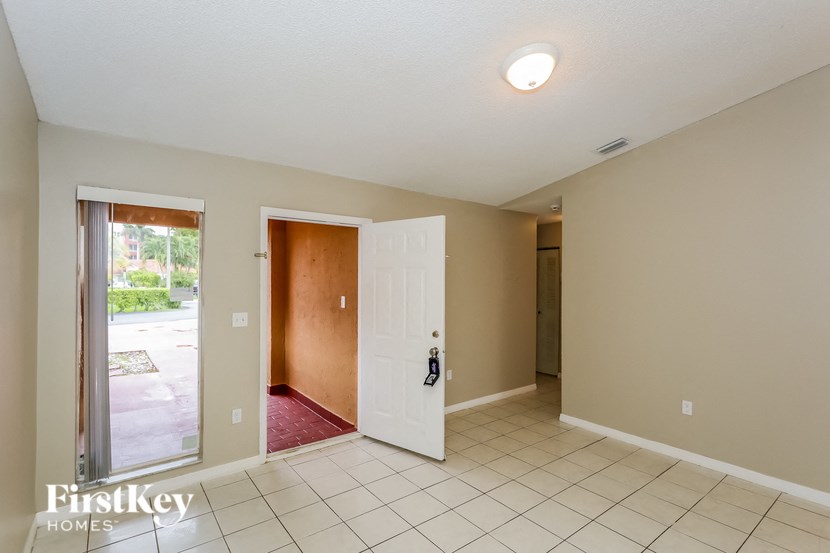 A room with a white door and a red carpet.