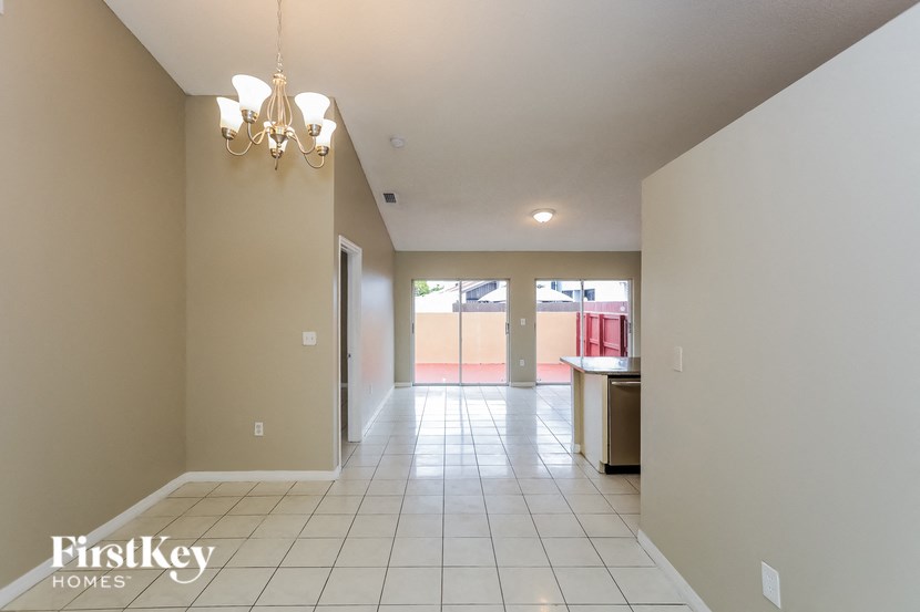 A long hallway with a chandelier and a FirstKey Homes logo.