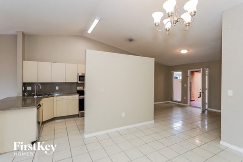 A kitchen with a refrigerator, sink, and cabinets.