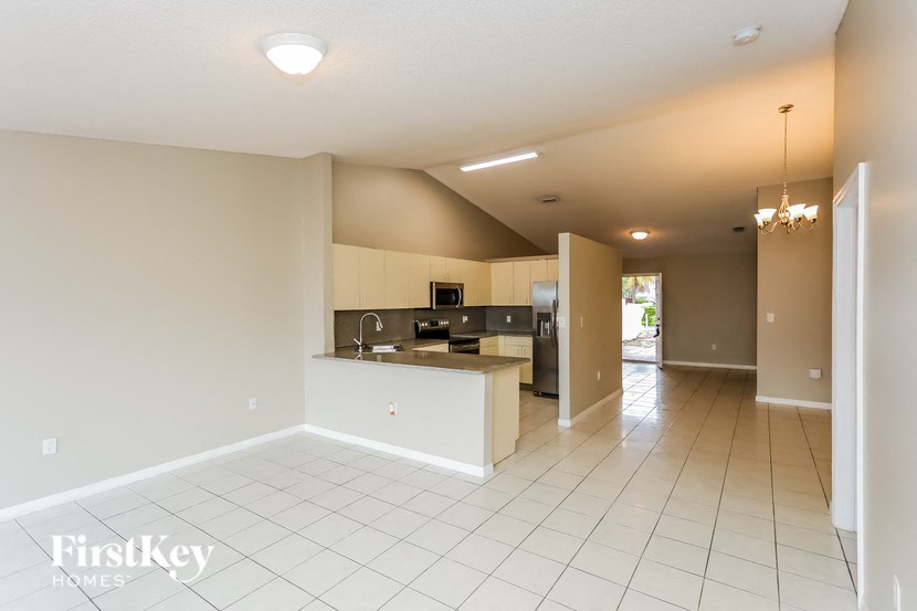 A spacious kitchen with white tiled floors and a modern design.