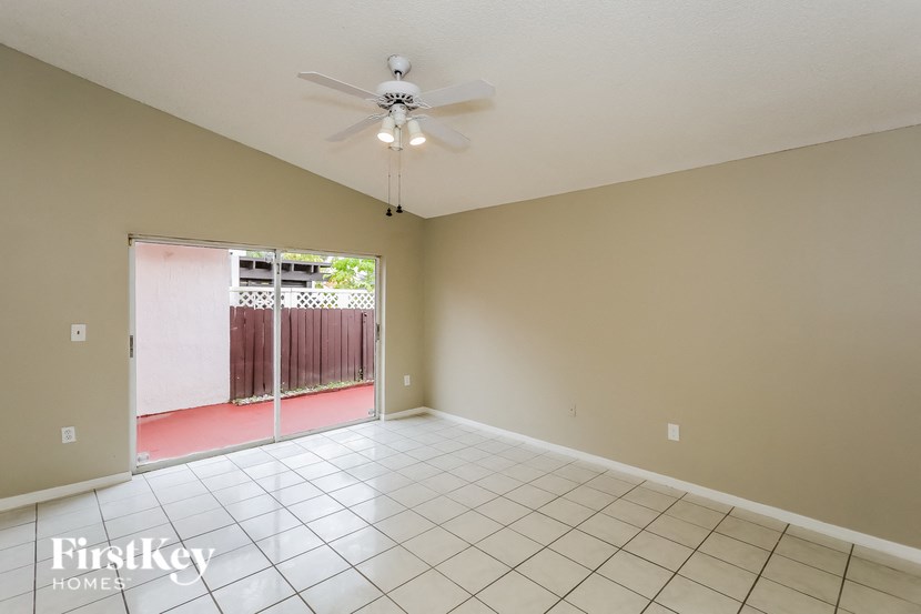 A room with a ceiling fan and tiled floor.