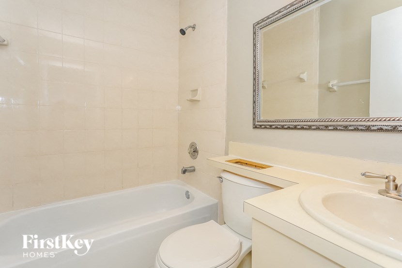 A white toilet sits next to a bathtub in a bathroom.