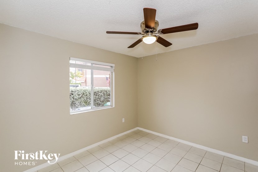 A room with a ceiling fan and a window.