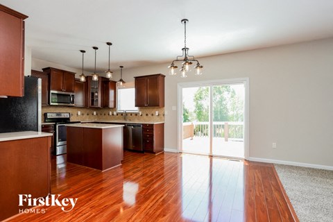 A kitchen with wooden cabinets and a black fridge.