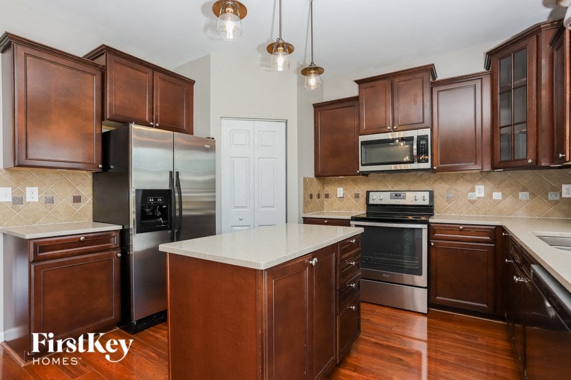 A kitchen with wooden cabinets and a white island.
