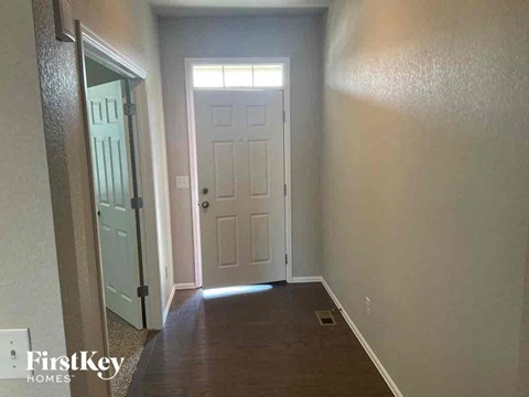 A hallway with a white door and a white door frame.