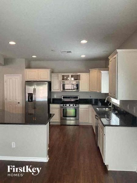 A kitchen with white cabinets and a stainless steel refrigerator.