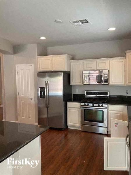 A kitchen with wooden floors and stainless steel appliances.