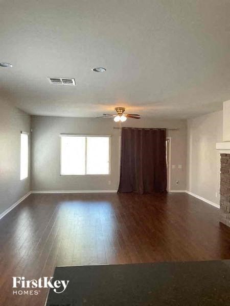 A spacious room with wooden floors and a fireplace.