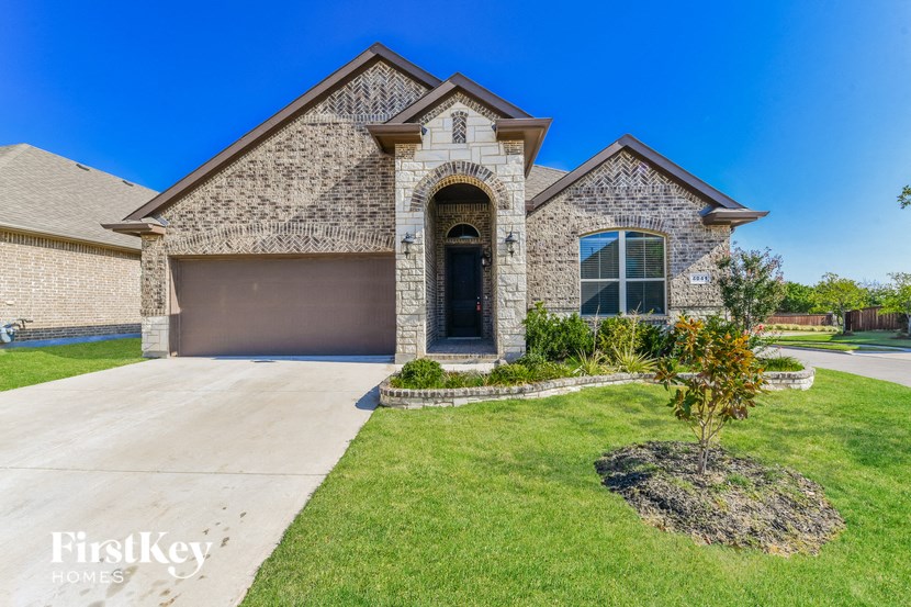 a large brick house with a driveway and a garage door