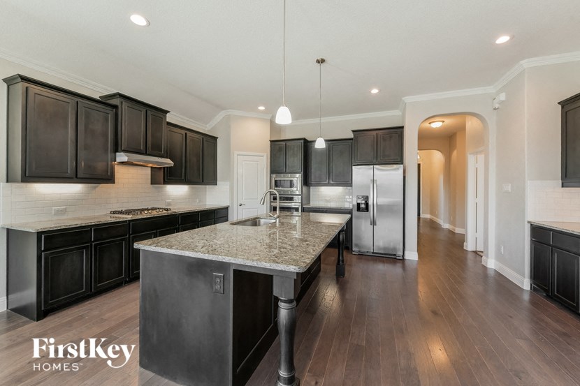 a kitchen with black cabinets and a marble counter top
