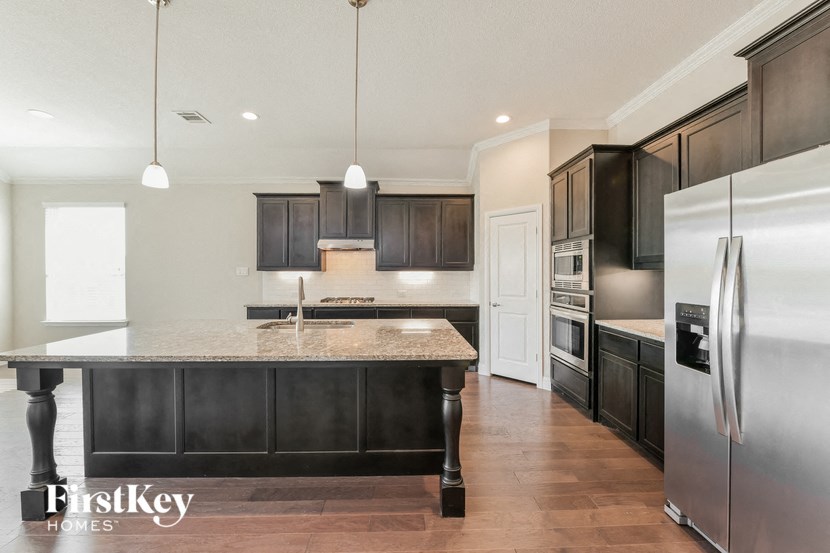 a kitchen with stainless steel appliances and a marble counter top