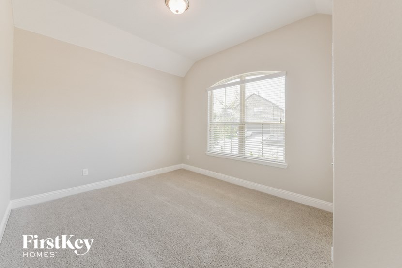 a bedroom with a carpeted floor and a large window