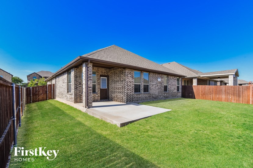 a brick house with a yard and a wooden fence
