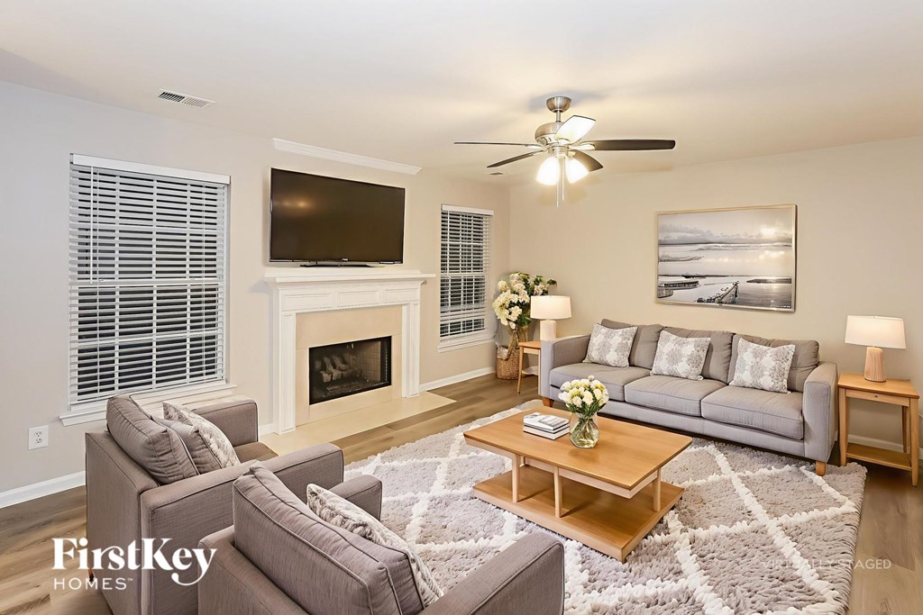 A living room with a grey couch, a coffee table, a fireplace, and a television.