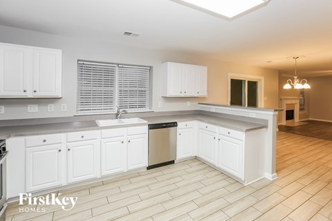 A kitchen with white cabinets and a tiled floor.