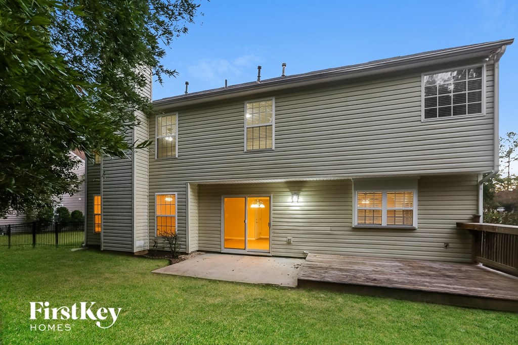 A house with a grey siding and an orange door is for sale by FirstKey Homes.