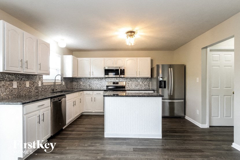 a kitchen with white cabinets and granite counter tops