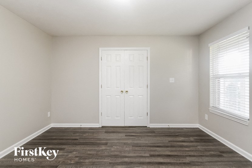 the living room of a new home with a white door and wood floors