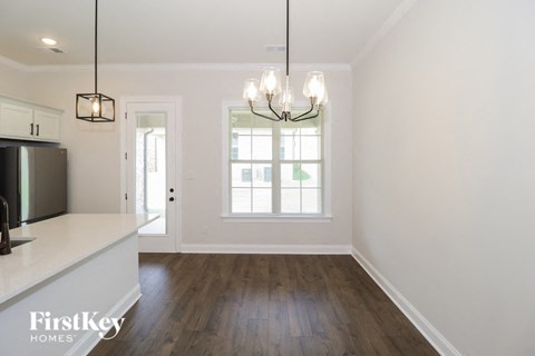 A kitchen with a white counter top and a fridge on the left.