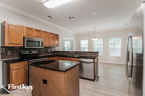 A kitchen with wooden cabinets and a black countertop.