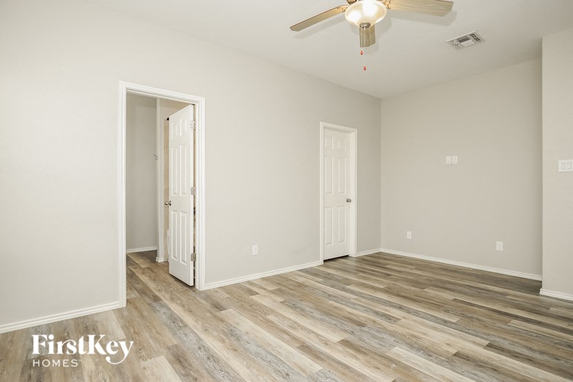 a living room with wood flooring and a ceiling fan