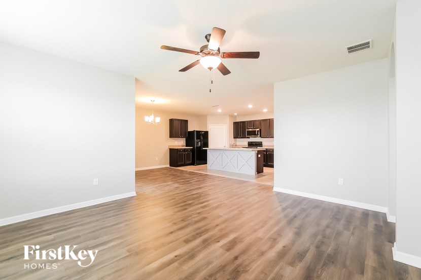 A spacious room with a ceiling fan and wooden flooring.