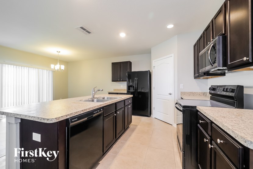 A kitchen with black appliances and a FirstKey Homes logo.