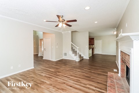 a living room with a fireplace and a ceiling fan