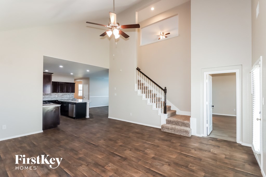A spacious living room with a staircase leading to the upper floor.