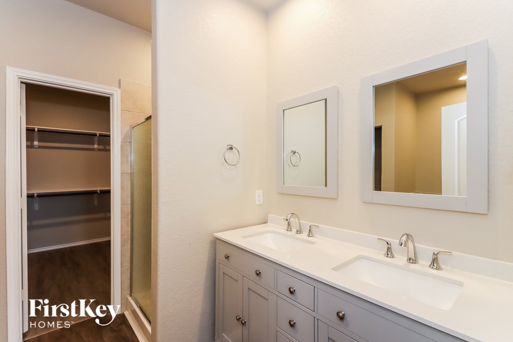 A bathroom with a white sink and a mirror above it.