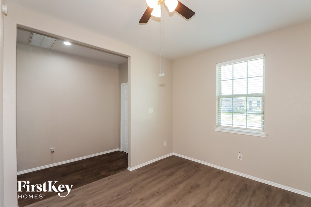 A room with a ceiling fan and a window.