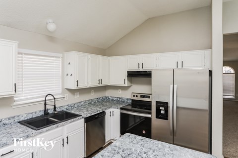 a kitchen with white cabinets and stainless steel appliances
