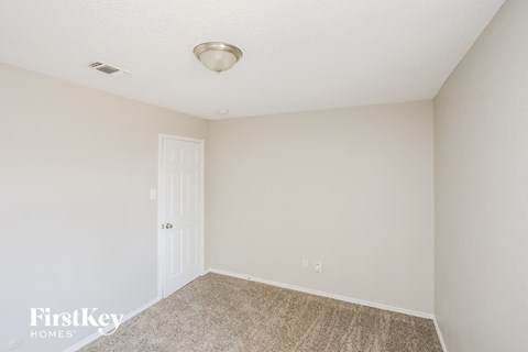 a bedroom with white walls and carpet and a white door