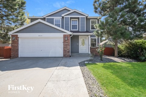 A house with a garage and a driveway in front of it.
