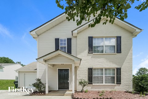 A two-story house with a white exterior and a black door.